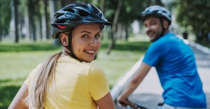 Zwei Fahrradfahrer*innen mit Helm