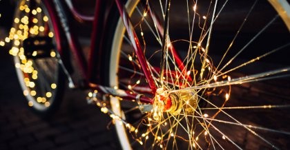 Fahrrad mit Lichterkette behangen auf dunkler Straße