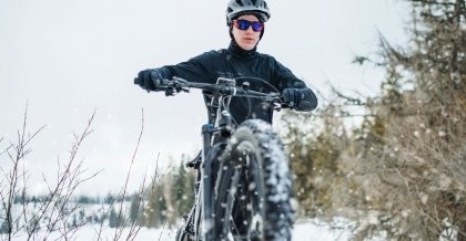 Mann im Schnee auf dem Fahrrad