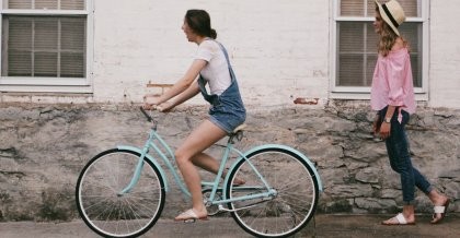 Frau fährt auf einem türkisen Fahrrad im Frühling